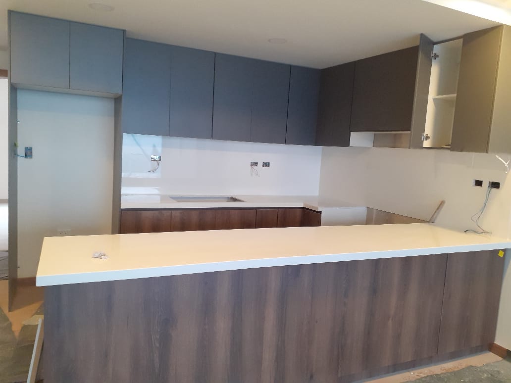 Cocina con barra frontal y muebles de dos tonos