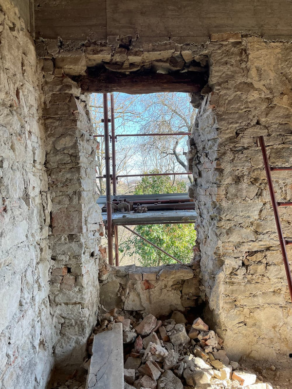 A picture of a window in a wall made of stone... and some kind of rubbish.