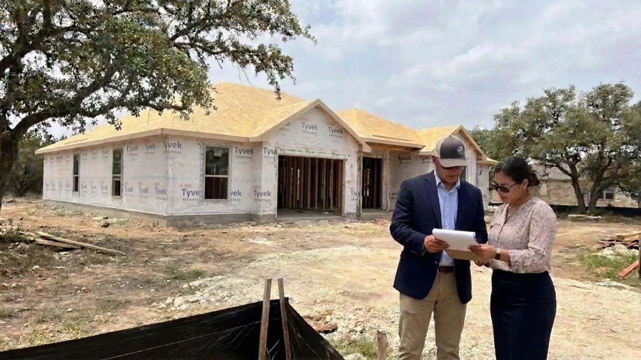 Affordable Concrete San Antonio crew member reviewing a site plan and permit documents on a San Antonio residential job site before pouring a concrete patio — licensed contractors registered with the city can pull permits on behalf of the homeowner