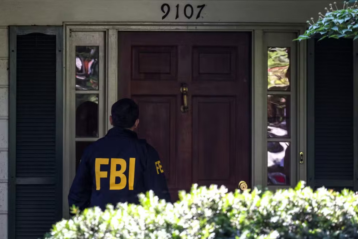 Agente do FBI na porta da casa do ex-agente de Segurança Nacional dos EUA, John Bolton, durante operação de buscas em sua residência, em 22 de agosto de 2025
