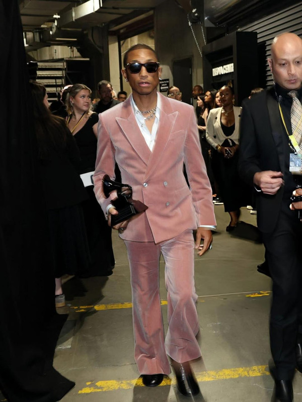 pharrell rising the trophy of Dr Dre Global Impact Award at the Grammys Getty Revolt