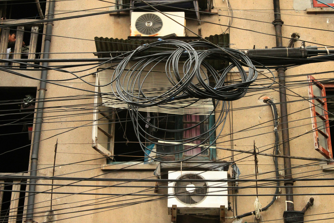 Street view of a power line tower against the sky.