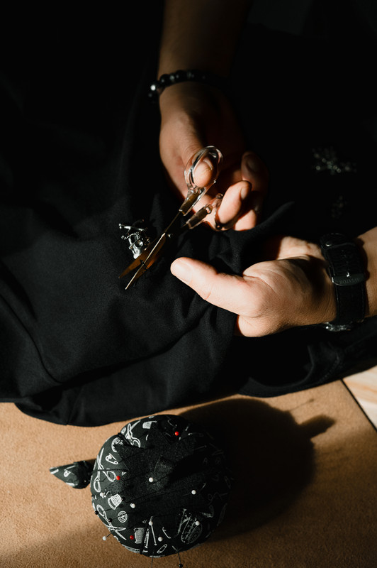 Flat lay — pins, emblem and scissors