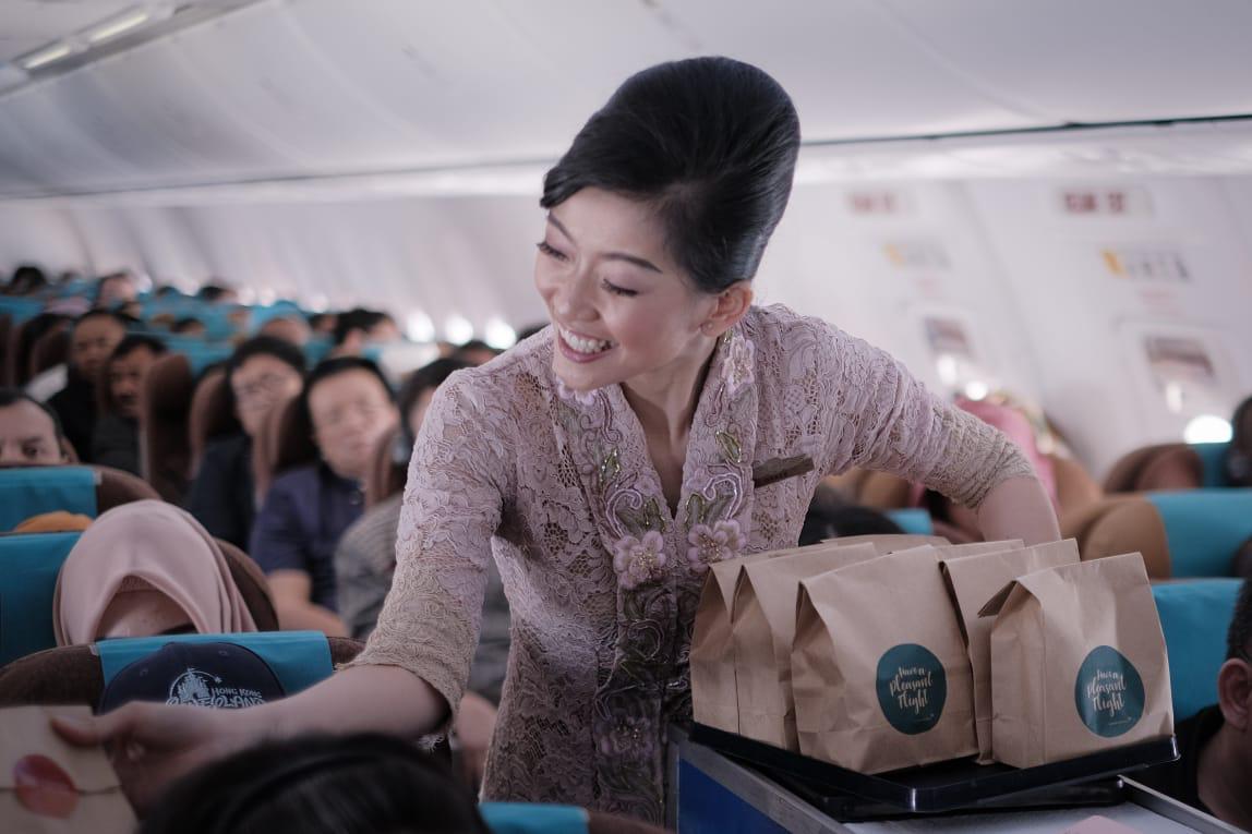 Pramugari Garuda Indonesia saat sedang memberikan pelayanan kepada para penumpang.