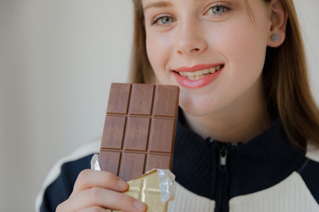 Woman holding a dark chocolate bar in her hand