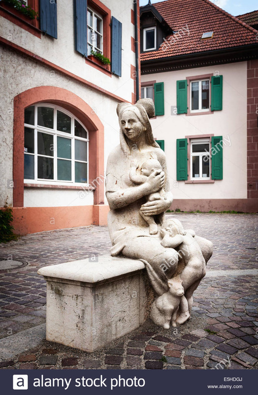 concrete-statue-of-mother-with-two-children-and-cat-sitting-on-the-E5HDGJ