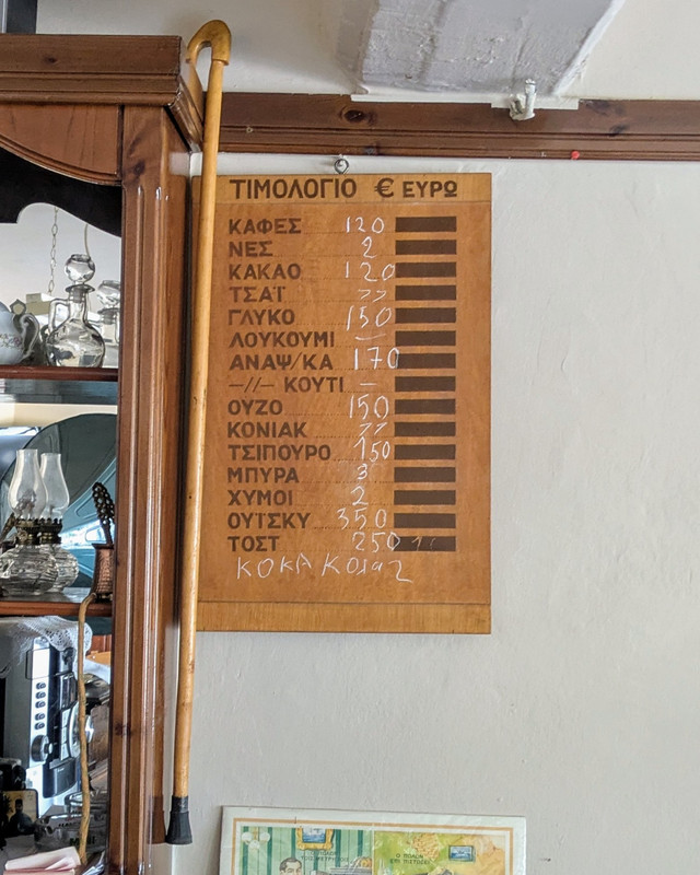 A price list written in a wooden board hanging on a wall