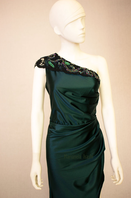 Long evening dress in satin bottle green with asymmetrical one-shoulder design and lace and rhinestone details.