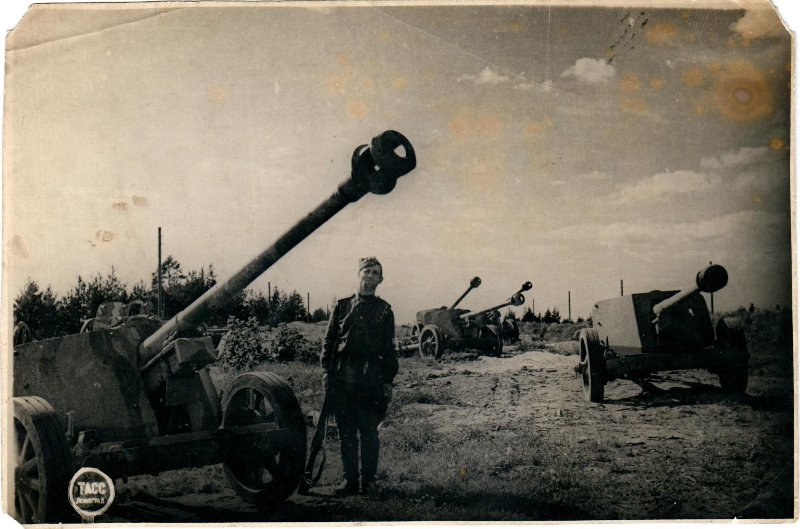 Советский солдат рядом с трофейными немецкими орудиями 1944