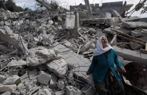 Palestinian-woman-weeps-as-she-stands-in-front-of-her-house-that
