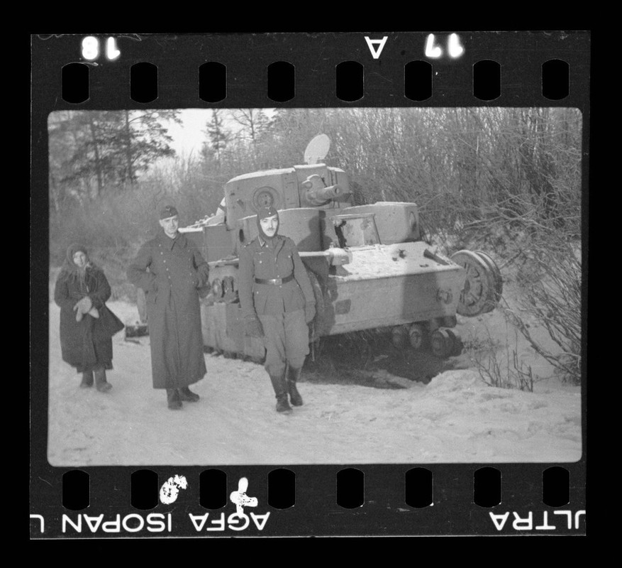 Soldaten neben zerstörtem Panzer