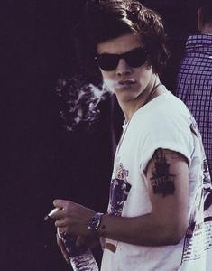 Harry Styles smoking a cigarette (or weed)
