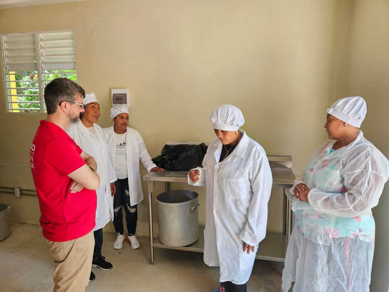 Coordinador de Prodiversa junto a beneficiarias en la procesadora de Café