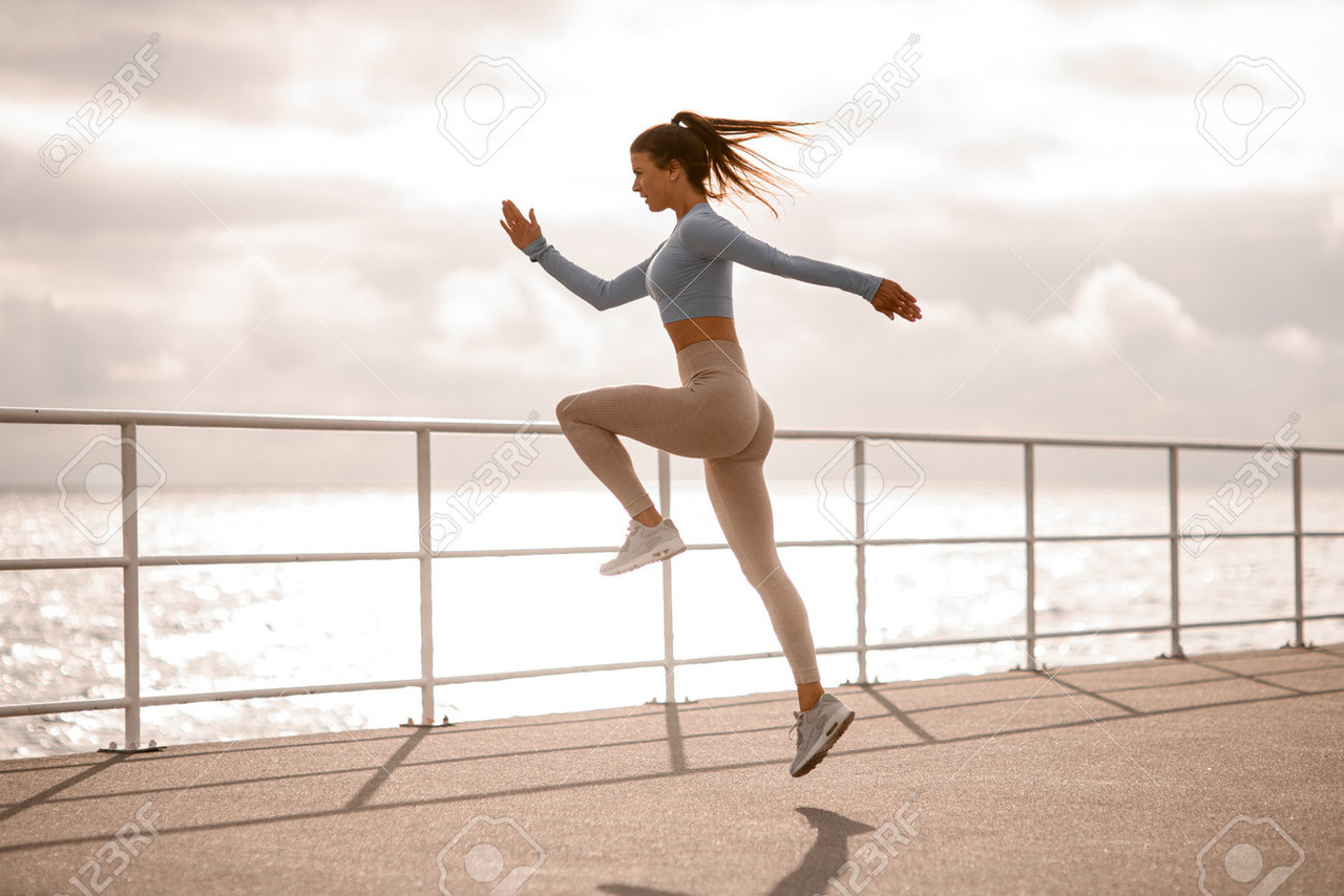 legins1909 beautiful shot of one caucasian woman running and jumping female exercising outdoors