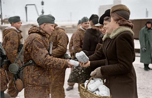 Unas chicas estonias dan comida a los soldados de la 20ª División SS Estonia que marchan hacia el frente
