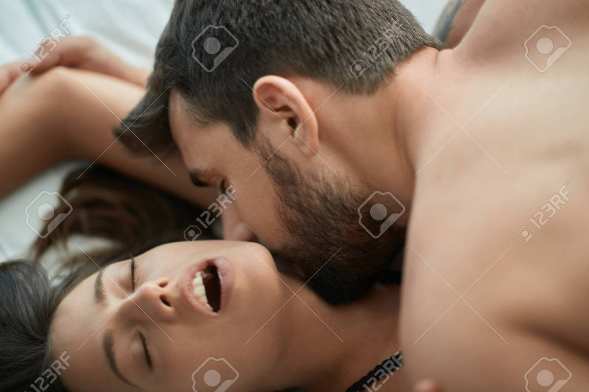 113487997-jeune-couple-passionné-homme-et-fille-faisant-l-amour-au-lit