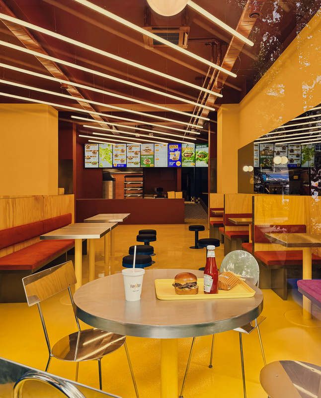Licht- und Materialdetail bei Flip-N-Fry mit intensiven Farbflächen und architektonisch integrierter Beleuchtung
