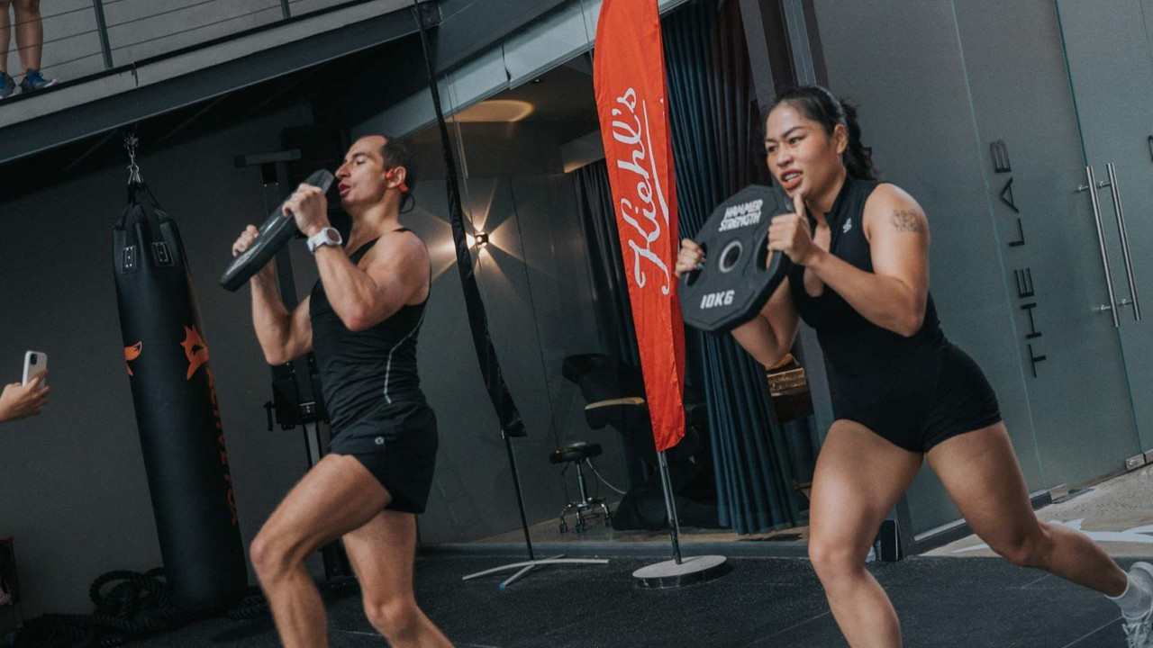 Hai hội viên Active Fox tập kết hợp sức mạnh và sức bền với tạ đĩa 10kg ở cường độ cao, minh họa concurrent training để vừa tăng cơ vừa tăng sức bền tại TP.HCM