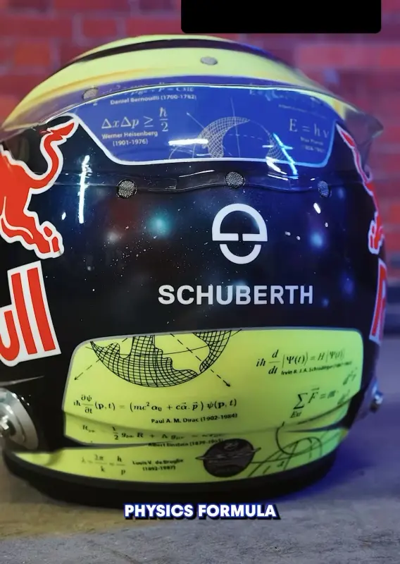 Photo of the helmet of Isack Hadjar.  The helmet is mostly Red Bull dark blue with the name of one of the sponsors, Schuberth, across the middle.  Underneath the sponsor is a yellow section with equations on.  Some of them are Newton, Einstein and Schrödinger.