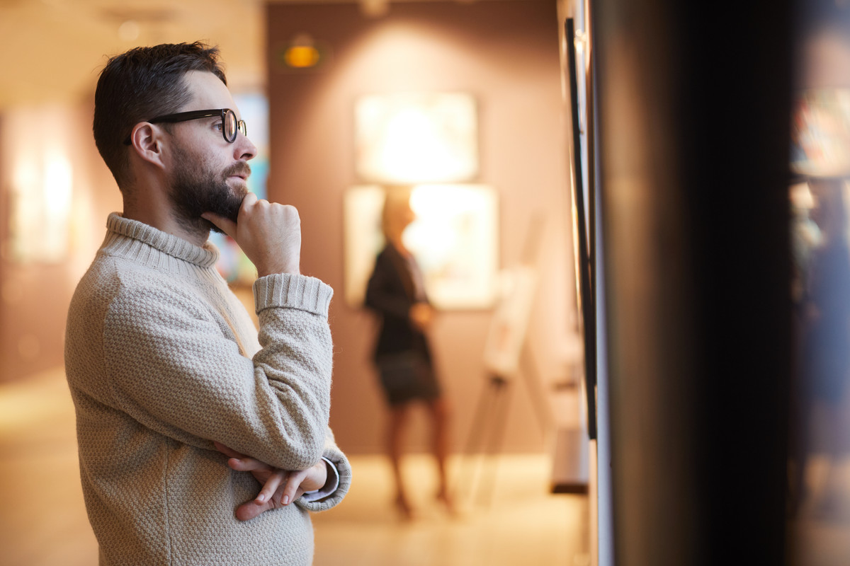 bearded-man-looking-at-paintings-in-art-gallery-2021-09-24-04-06-33-utc