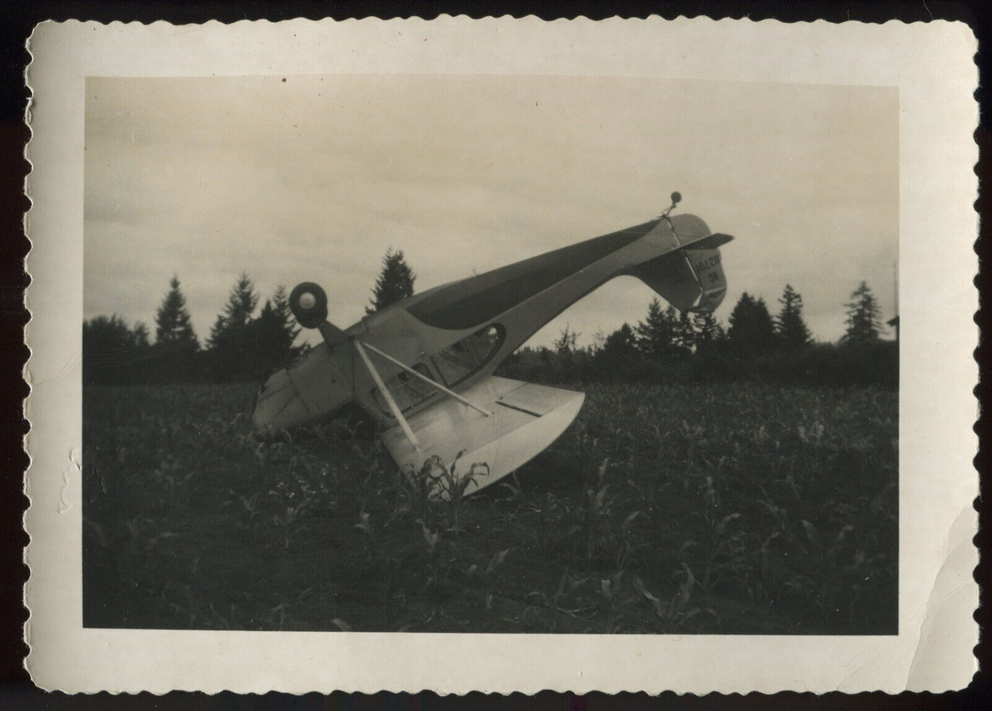 Small airplane upside down in a field.
