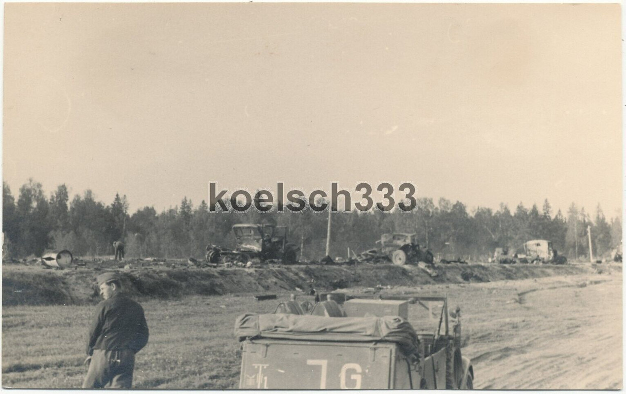 Foto Kübelwagen der 18. Panzer Div. vor russischen LKW Wracks auf einer Rollbahn
