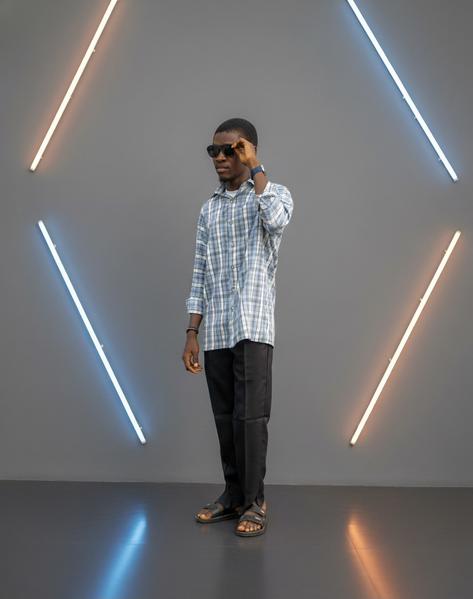 FAWLUX CEO Abdulkareem Fawaz showcasing bespoke shirt and trouser craftsmanship in Lagos