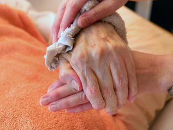 dementia patient hands being wiped with rag