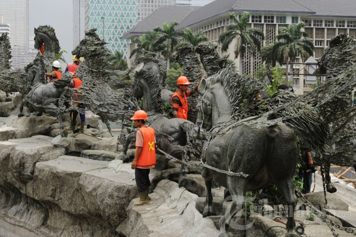 Pekerja membersihkan patung Arjuna Wijaya di Jalan Medan Merdeka Barat, Jakarta Pusat, Rabu (29/10/2014). Bank OCBC NISP kembali mendanai pemugaran patung ini bekerjasama dengan Dinas Pertamanan dan Pemakaman DKI Jakarta karena patung yang diresmikan Presiden kedua RI, Soeharto pada tahun 1987 ini kelayakan fungsinya sudah tidak optimal dan perlu ditata kembali.