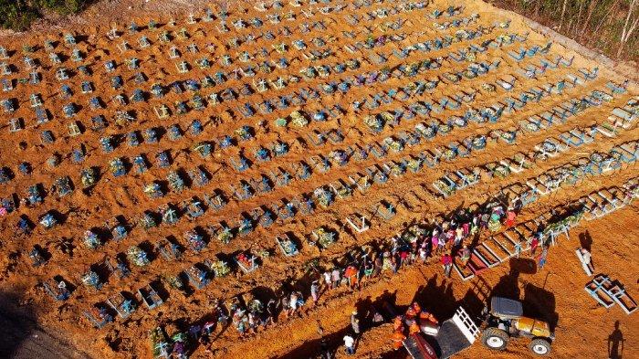Sebuah foto udara dari para pekerja pemakaman yang menurunkan peti mati dari sebuah truk di sebuah area di mana kuburan-kuburan baru digali terlihat di pemakaman Parque Taruma, selama pandemi Covid-19 coronavirus di Manaus, negara bagian Amazonas, Brasil, 21 April 2020.