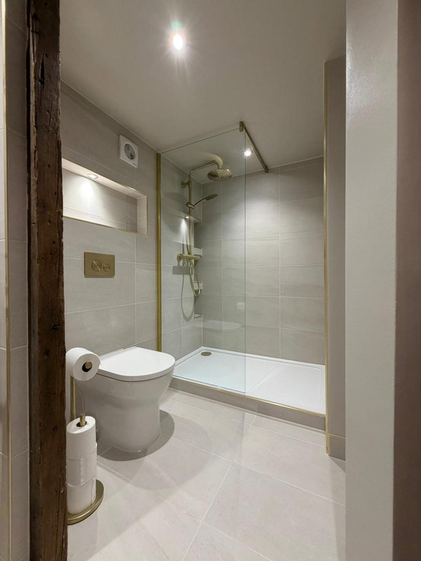 Finished shower area with brass fittings and rustic bathroom details