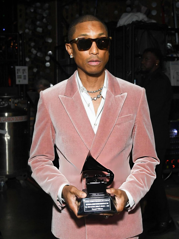 pharrell_rising_the_trophy_of_Dr_Dre_Global_Impact_Award_at_the_Grammys_Getty_Revolt_(2)