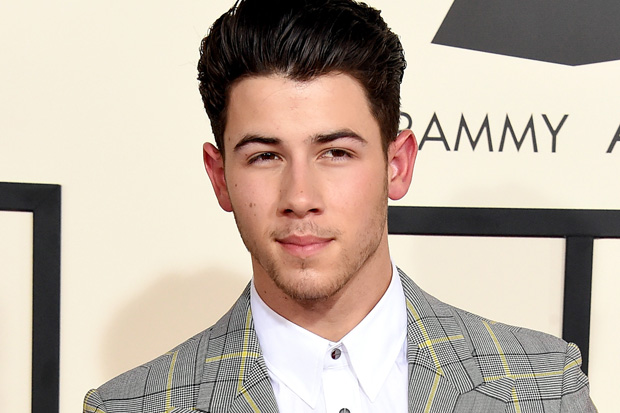 Nick Jonas s 2023 Mörk brun hår & gangster hårstil.
