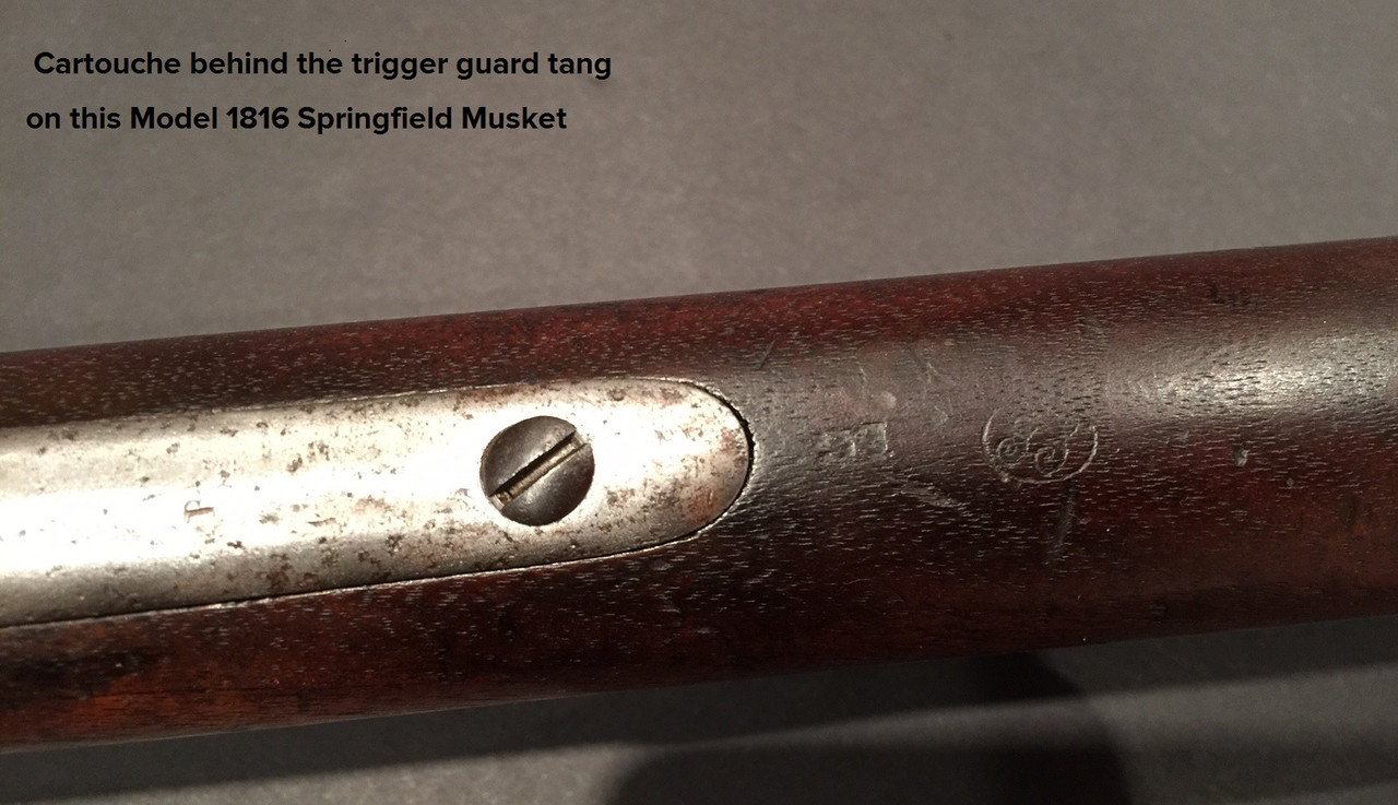 Cartouche behind trigger guard tang
