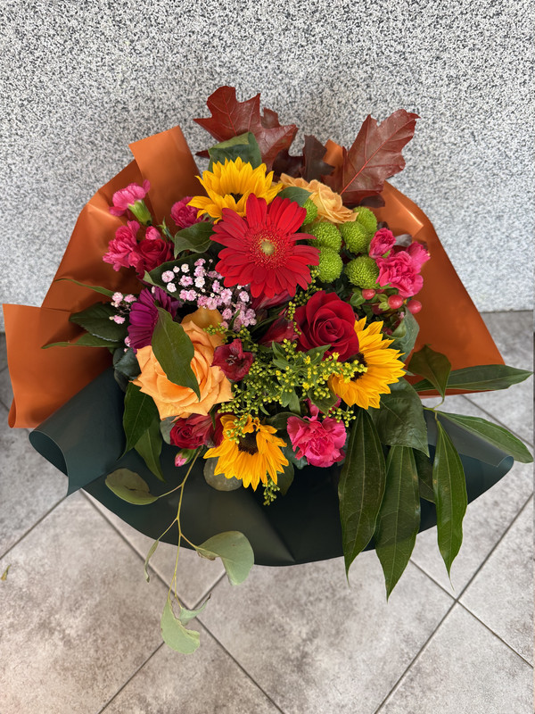 Bukiet 9 kolorowych mieszanych kwiatów, w tym sezonowych z  przybraniem w ozdobnej kryzie ze wstążką