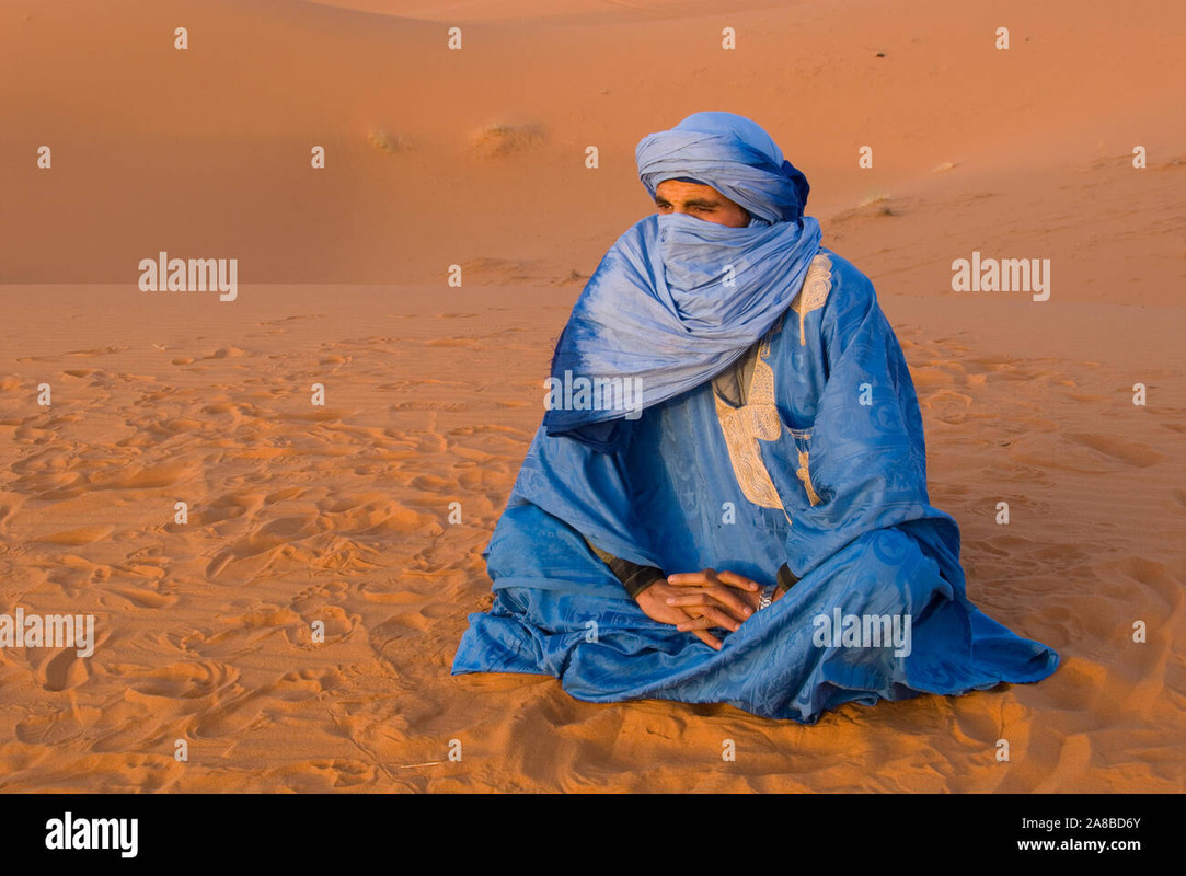 velado-tuareg-hombre-sentado-sobre-la-arena-erg-chebbi-marruecos-2a8bd6y