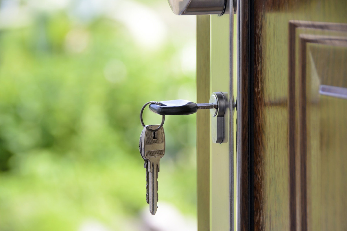 A house key opening a door.