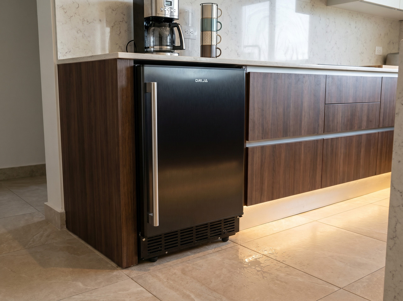 Fábrica de hielo empotrable Drija con acabado negro brillante y manilla de acero inoxidable instalada en un mueble de cocina premium