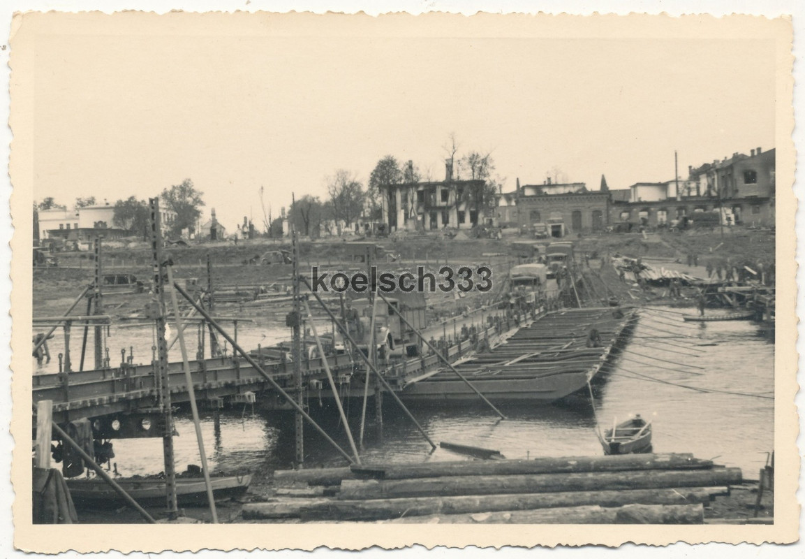 Foto LKW der Wehrmacht auf einer Kriegsbrücke vor Ruinen an der Ostfront 1941