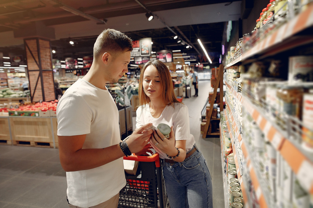 Couple checking food label nutrition information and calories while planning healthy meals
