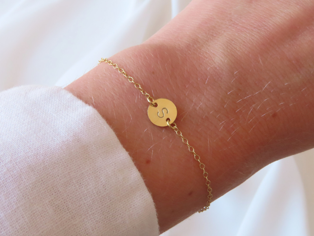 This dainty and personalizable disk bracelet is the perfect way to show off your personality. Crafted from 925 sterling silver and 18k gold plated, this bracelet is sure to turn heads wherever you go. The initial of your choice will be hand stamped onto the disk, making it a totally unique piece of jewelry that you can wear with pride. Whether you choose your own initial or a special memento of someone close to you, this bracelet is a wonderful way to express who you are. Perfect for everyday wear, it will add a touch of elegance to any outfit. Add this beautiful and personalized piece of jewelry to your collection today!