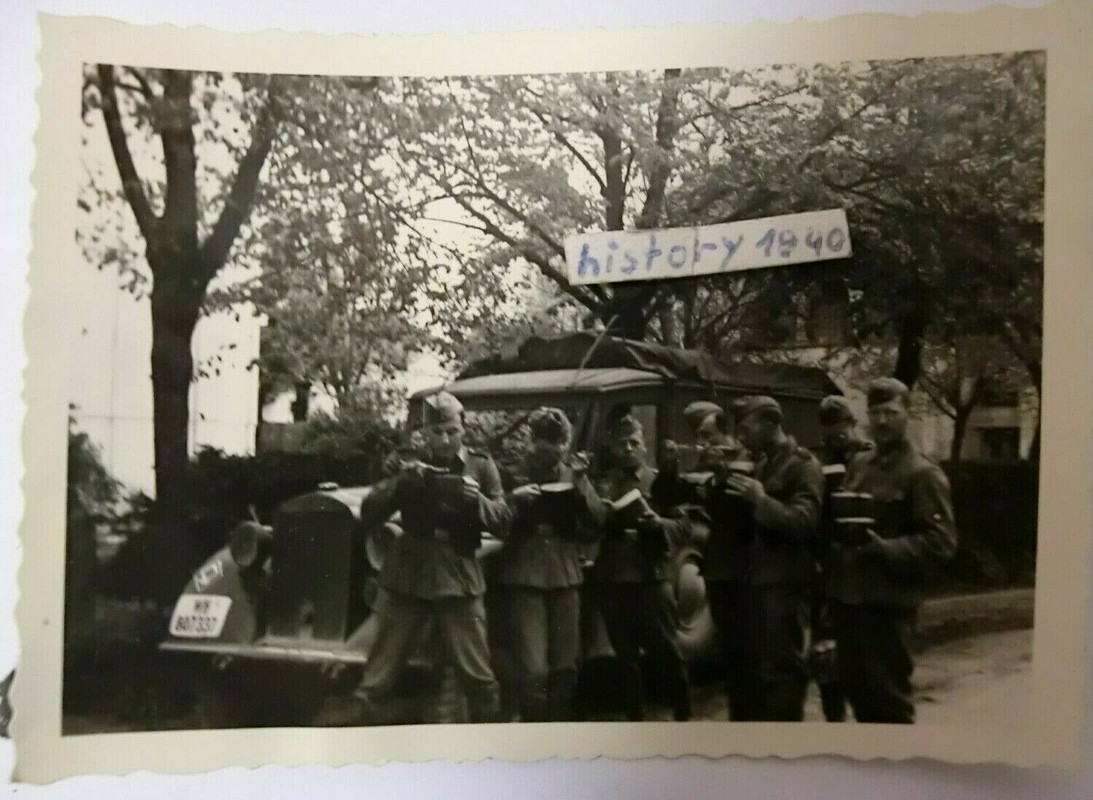 Foto mit Soldaten bei der Rast vor LKW - Plane mit Staffelwappen.(