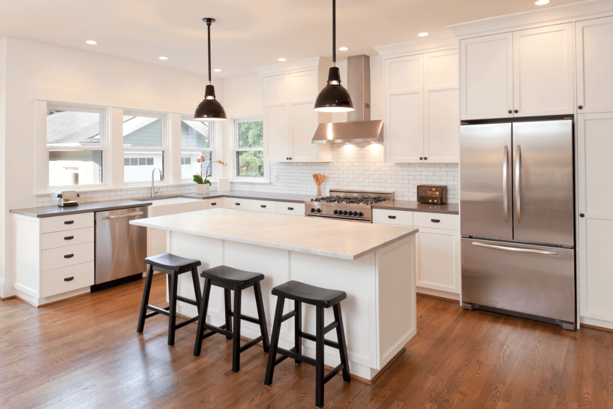 open concept kitchen with hardwood floors and stools