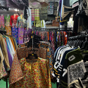 batik garment beside a sports jersey, surrounded by a bountiful colors of clothes