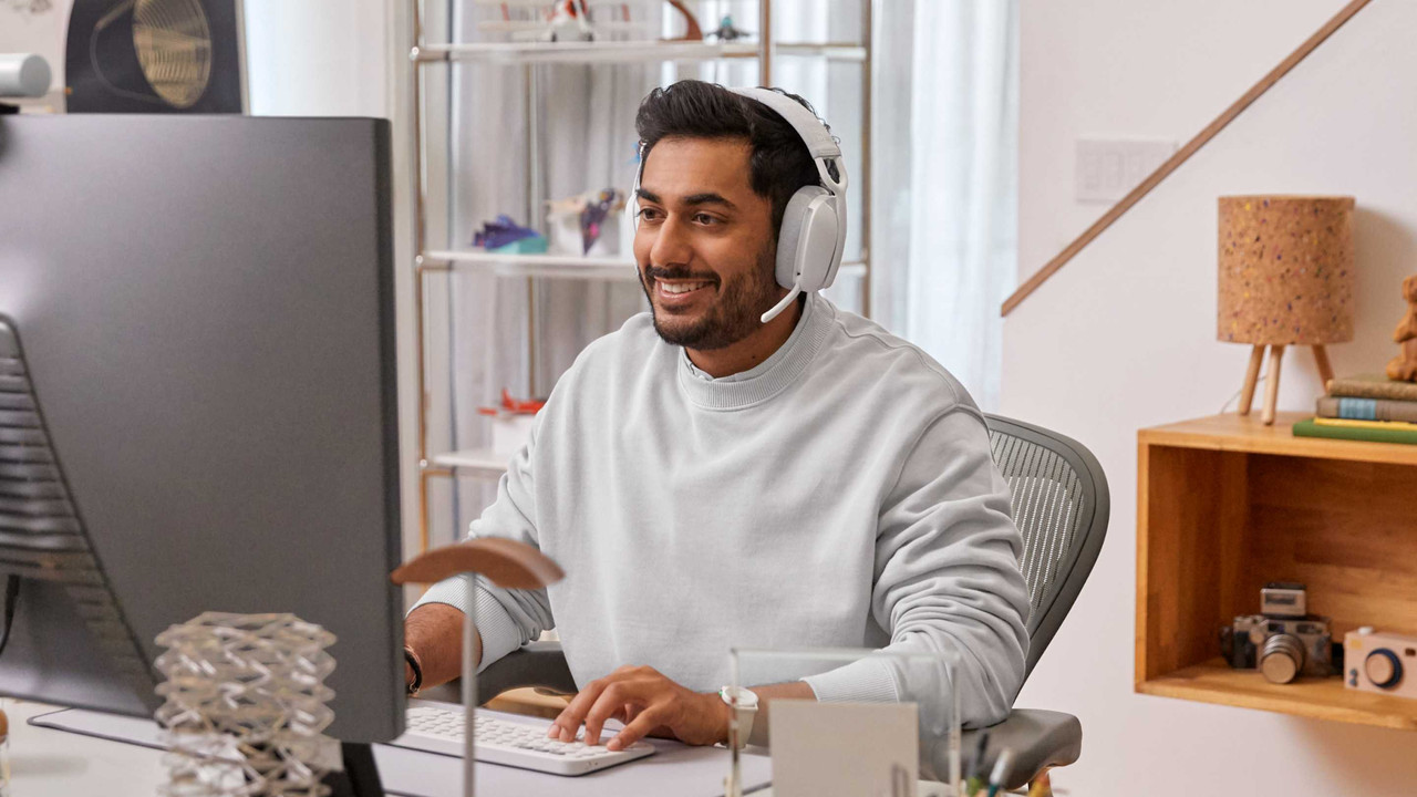 Una persona usando los audífonos Logitech Zone Vibe 100 en un ambiente moderno y casual.