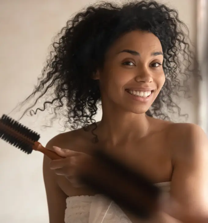 Girl brushes black curly hair