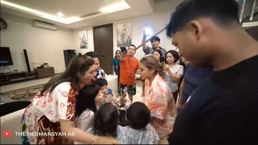 Ashanty meniup lilin di kue tart yang dibawakan oleh Aurel Hermansyah