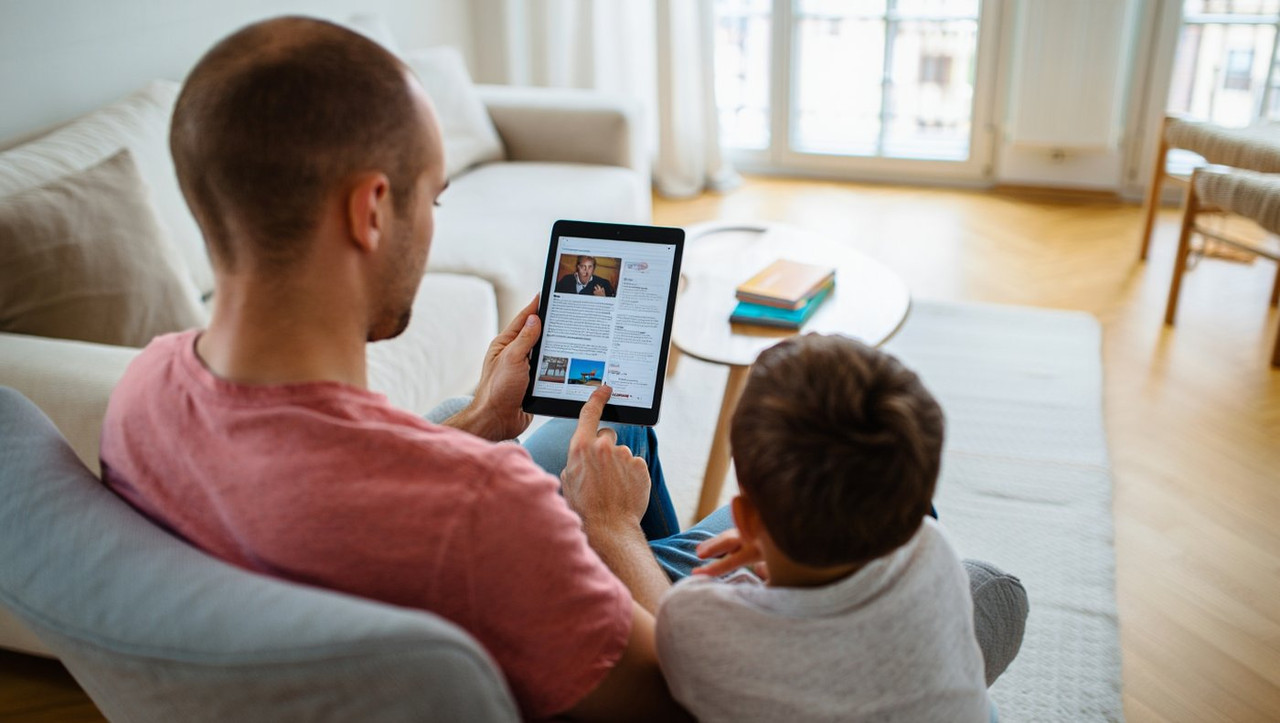 Родитель с планшетом демонстрирует признаки цифровой зависимости в семье