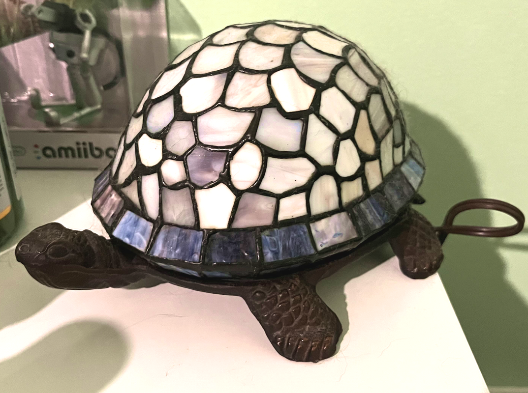 A lamp in the shape of a turtle, with a shell of stained glass