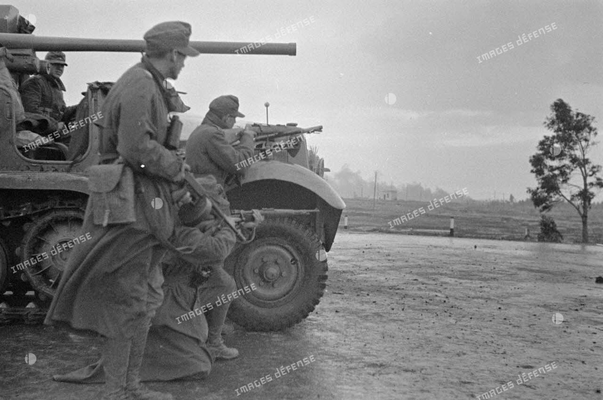 Au premier plan, canon de 3,7 cm PaK puis un semi-chenillé Sd.Kfz-6 transformé en véhicule blindé mu